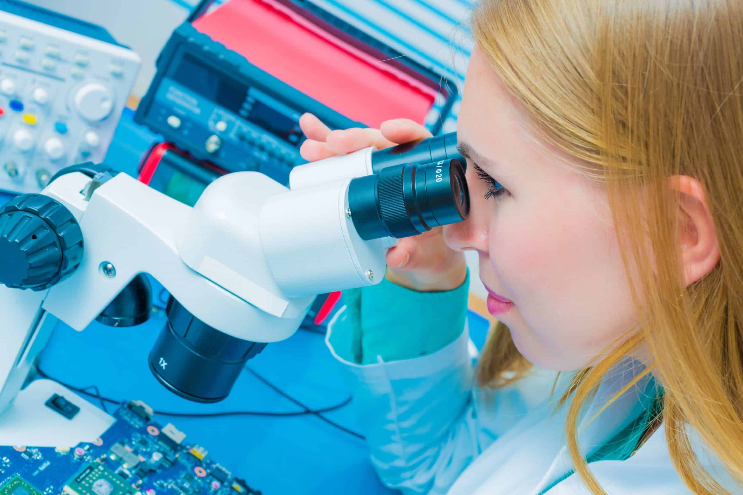 A technician examining a printed circuit board while practicing PCB testing techniques.